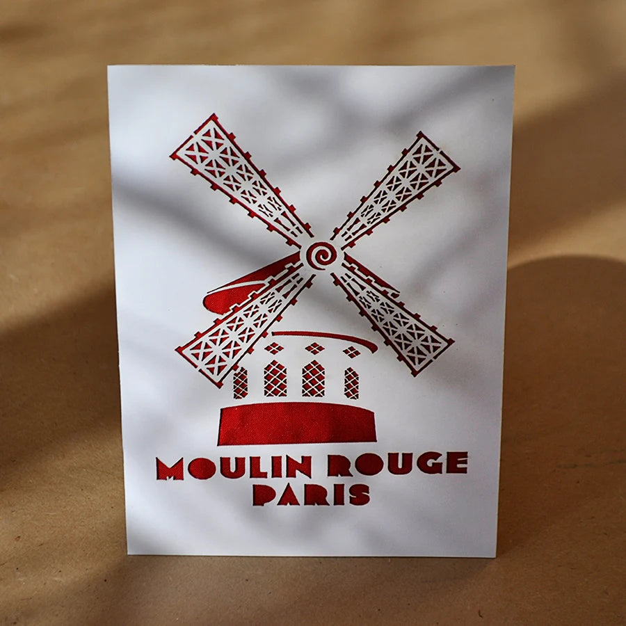 Visuel d'ambiance de la carte postale blanche et rouge de la façade du Moulin Rouge